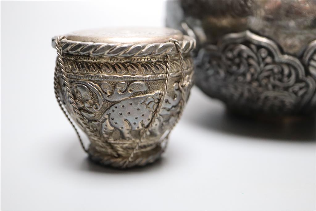 An Indonesian? embossed and engraved white metal squat vase, height 12.2cm and two similar lidded pots,